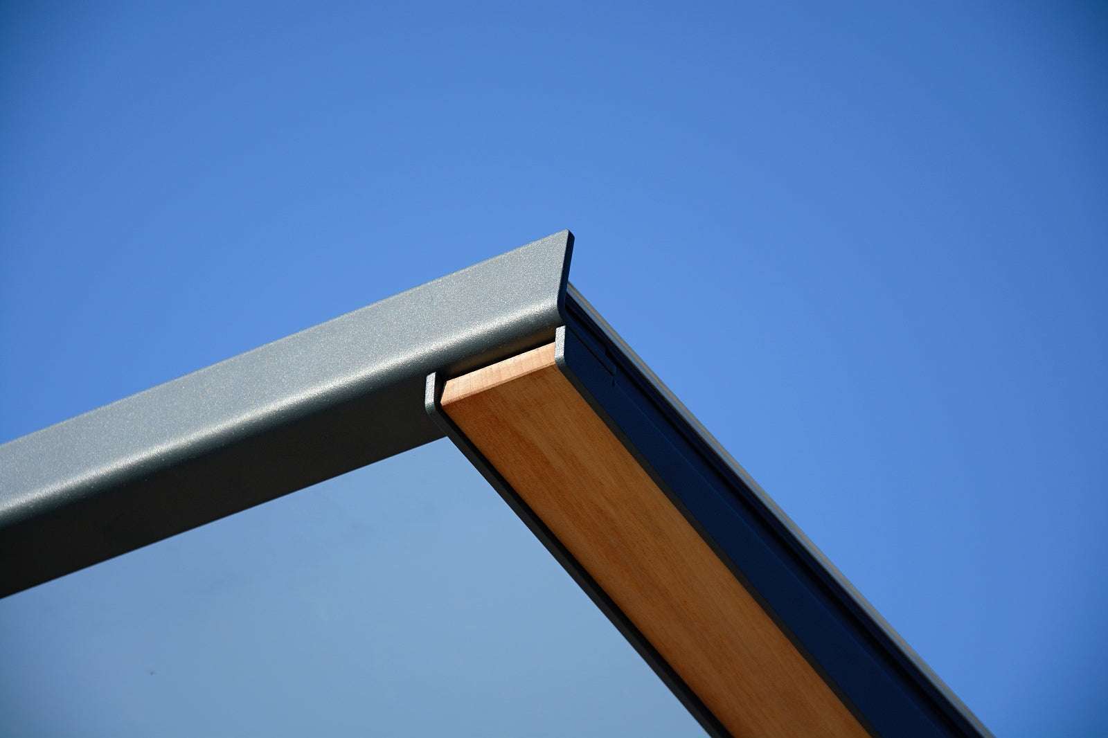 Moderne Glas- und Holzüberdachung unter blauem Himmel.